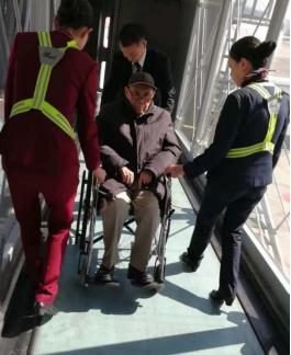 周力君和同事護(hù)送老人登機(jī).jpg