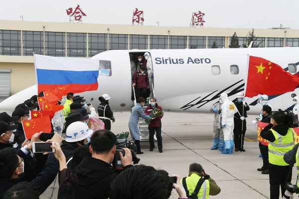 08專家組成員走下飛機收到鮮花，人們夾道歡迎.jpg