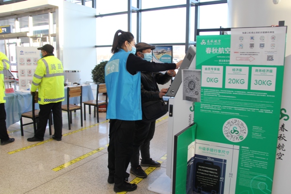 圖為：冬奧青年志愿者為老年旅客辦理自助值機  安冉攝.jpg