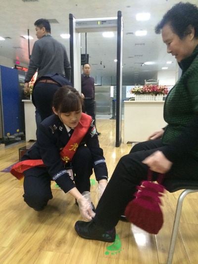 伊那機場暖冬行動志愿者協助老人安檢.jpg