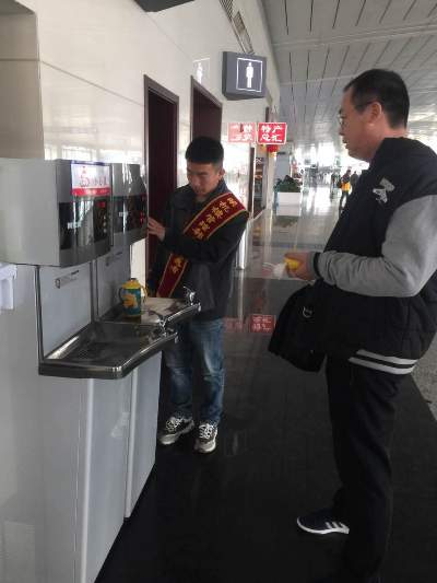 志愿者協助旅客使用飲水機.JPG