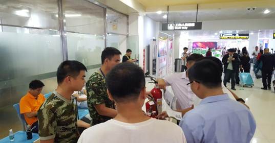 配圖:鳳凰機場消防支隊隊員為過往旅客和機場員工示范滅火器的使用方法.jpg